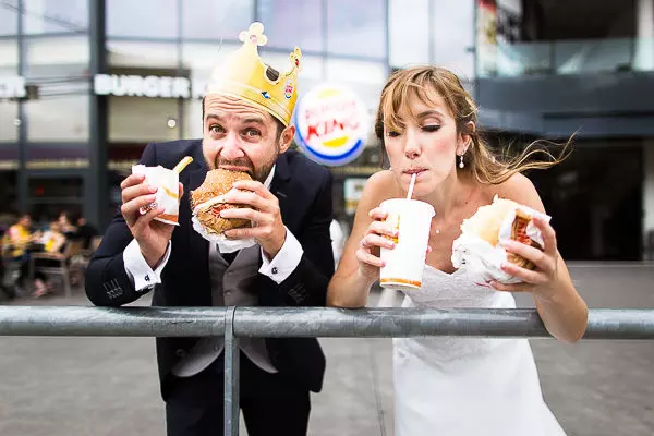 Photo d'un couple de mariés mangeant à Burger King en robe et costume