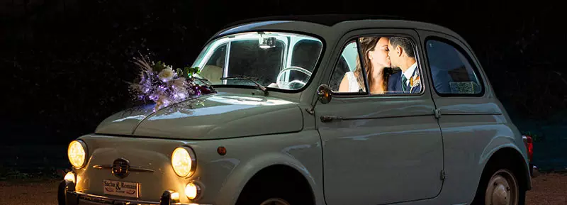 Photo de couple de nuit dans une Fiat 500 à la fin du mariage